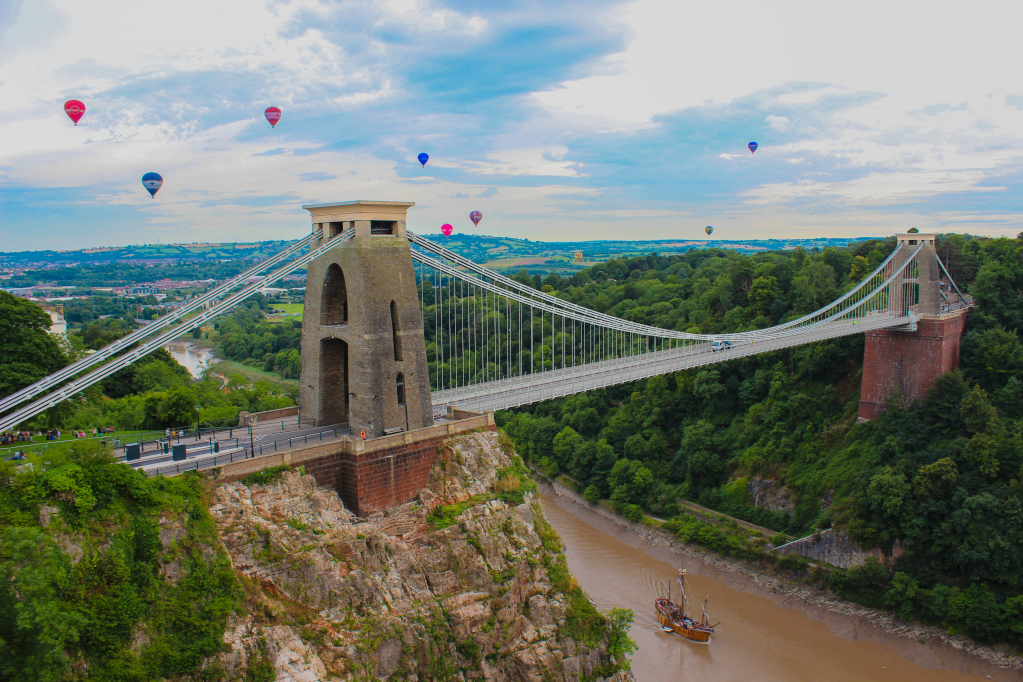 A view of the Clifton Suspension Bridge and the Avon gorge with hot air balloons floating above